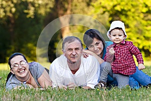 Grandpa, daughters and niece on grass photo