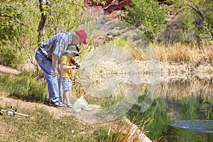 Grandpa fishing with his grandson at a beautiful lake