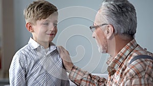 Grandpa giving advice to boy, teaching younger generation, sharing experience