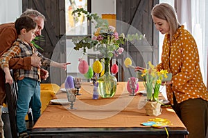 Grandpa, grandson and mother are getting ready for Easter dinner.