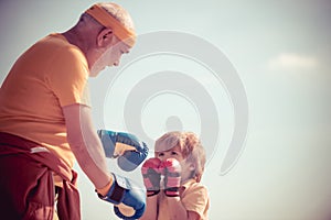 Grandpa and little child boy in boxing stance doing exercises with boxing gloves. Active leisure. Best cardio workout.