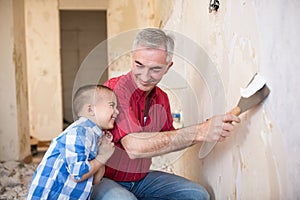 Grandpa takes off wallpaper and laughing with his grandson