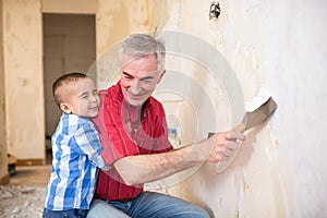 Grandpa takes off wallpaper and laughing with his grandson