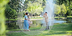 Grandpa takes pictures of granddaughter and grandma with his in park on sunny day happiness. concept grandparent and