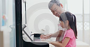 Grandpa teach girl play piano