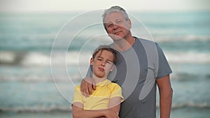 Grandpa with teenage grandchild by the ocean