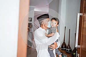 grandparent kissing his granchild at home during visit celebrating eid mubarak
