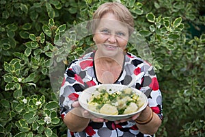 Grandparent woman with boiled potatoes in the plate