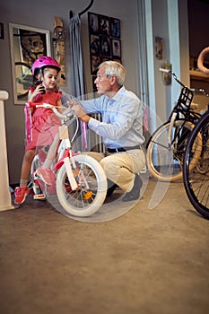 Grandparents buying new bicycle and helmets for little girl