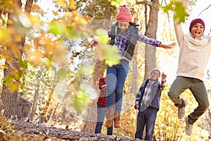 Grandparents With Children Walking Through Fall Woodland