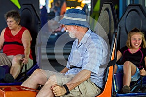 Grandparents and Grandaughter Ride Bumper Cars at an Amusement P