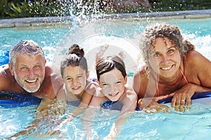 Grandparents With Grandchildren On Airbed In Swimming Pool photo