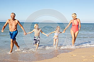 Grandparents With Grandchildren On Beach.