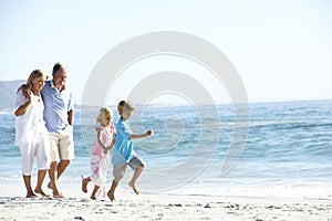 Grandparents and Grandchildren Walking Along Beach