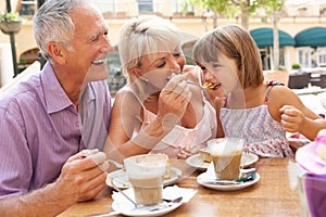 Grandparents With Granddaughter In Cafe