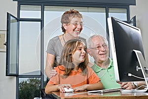 Grandparents and granddaughter with computer