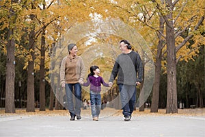 Grandparents and granddaughter playing in park