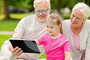 Grandparents and granddaughter with tablet pc