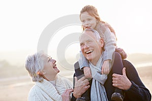 Grandparents And Granddaughter Walking On Winter Beach photo