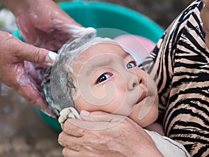 Grandparents hands washing cute child hair outdoor