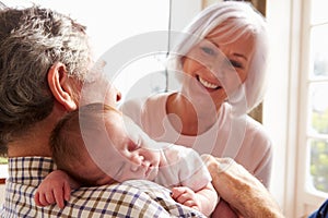 Grandparents Holding Sleeping Newborn Baby Granddaughter