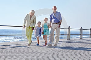 Grandparents make childhood even more special. grandparents walking hand in hand with their granddaughters on a