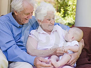 Grandparents outdoors on patio with baby photo