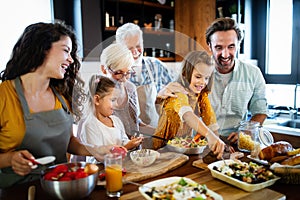 Grandparents, parents and children spending happy time in the kitchen