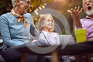 Grandparents playing  with  granddaughter.Girl  enjoying with her grandparents outdoor at home