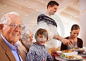 Grandparents, portrait and family at dinner on Christmas, together with food and celebration in home. Happy, event and