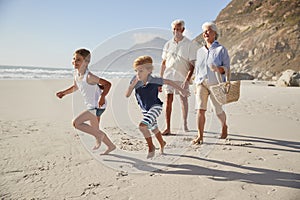 Grandparents Running Along Beach With Grandchildren