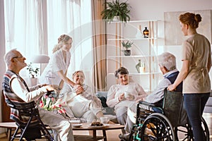 Grandparents spending time in common room with their caregivers photo