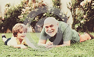 Grandson embrace his grandfather. Happy family father and child on meadow with a kite in the summer on green grass. Cute