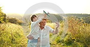 Grandson and granfather spending time together on summer meadow