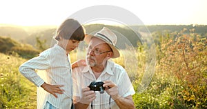Grandson and granfather spending time together on summer meadow