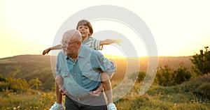 Grandson and granfather spending time together on summer meadow