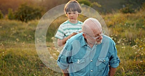 Grandson and granfather spending time together on summer meadow