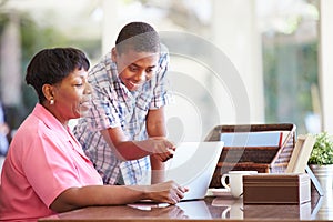 Grandson Helping Grandmother With Laptop photo