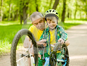 Grandson with his grandfather pumped wheel bicycle