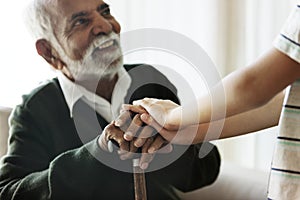 Grandson holding grandpa`s hands with care photo