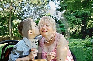 Grandson hugs and kisses on the cheek his grandmother. tears in