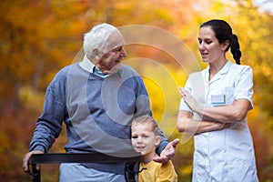 Grandson spending time in the park with disabled senior grandfather