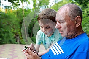 Grandson teaches grandfather how to use smartphone