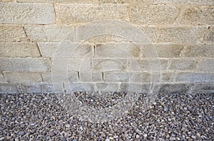 Granite ashlars wall with river pebble stones as ground photo
