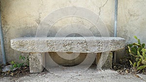 A granite bench along the wall of an old abandoned house.