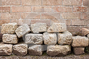 Granite Blocks Piled in front of Brick Wall