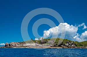 Granite coastline view of the tropical island of Marianne in Seychelles with blue sky photo