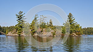 Granite Island with trees in a Muskoka lake