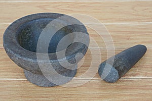 Granite mortar and pestle on wooden background