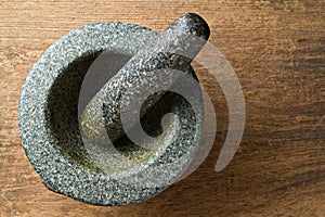 Granite mortar on wooden background.